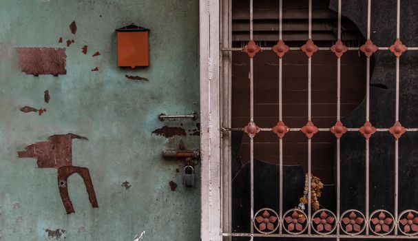 Detail of an old house with blue wooden door and steel window frame. Facade of an old traditional house. Selective focus.