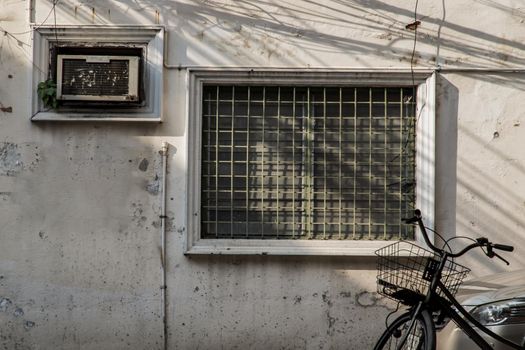 Steel window frame and the vent shade side on wall of an old house. Selective focus.