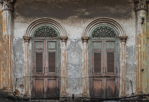 Brown vintage two wooden doors on the old wall. Western Architecture style, Selective focus.
