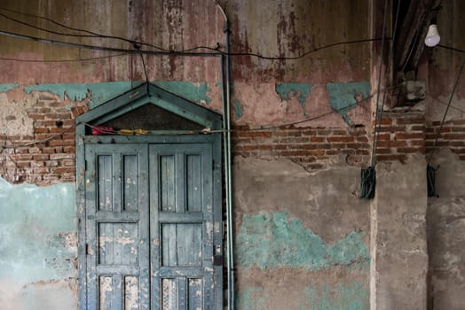 Old wood vintage door on the old wall with visible bricks texture was left to deteriorate over time. Traditional Architecture style, No focus, specifically.