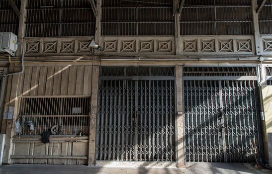 Front view of entrance of the building and old steel metal shutter and folding door gate on old industrl building. No focus, specifically.
