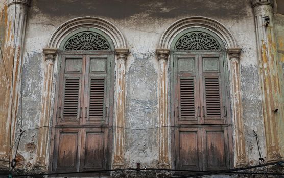 Brown vintage two wooden doors on the old wall. Western Architecture style, Selective focus.