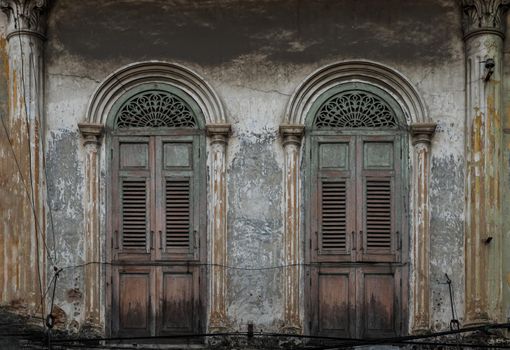 Brown vintage two wooden doors on the old wall. Western Architecture style, No focus, specifically.