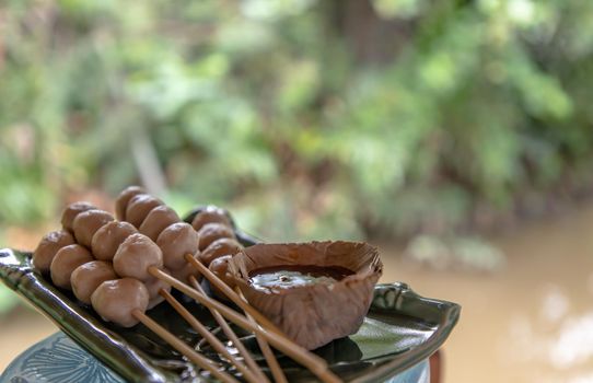 thai style pork ball grilled served with spicy-sweet dipping sauce. It is a delicious appetizer. Copy space, Selective focus.