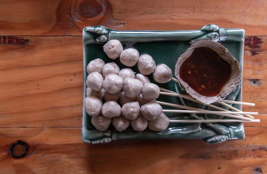 thai style pork ball grilled served with spicy-sweet dipping sauce. It is a delicious appetizer. Top view, Copy space, Focus and blur.