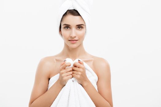 Beauty and Skin care concept - Beautiful caucasian Young Woman with bath towel on head covering her breasts, on white.