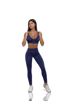 brunette girl in blue leggings and top on a white background