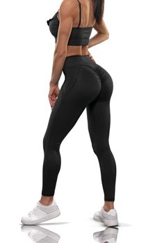 brunette girl in black leggings and a top stay back on a white background