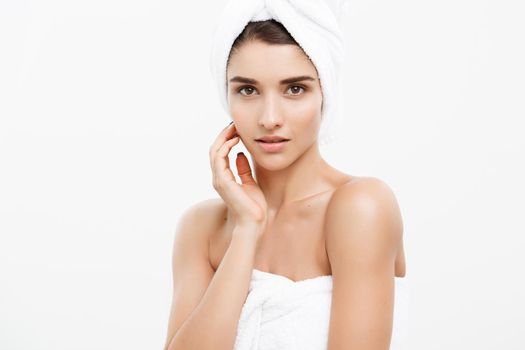 Beauty and Skin care concept - Beautiful caucasian Young Woman with bath towel on head covering her breasts, on white