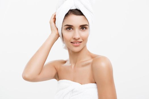 Beauty and Skin care concept - Beautiful caucasian Young Woman with bath towel on head covering her breasts, on white