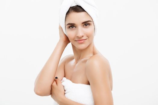 Beauty and Skin care concept - Beautiful caucasian Young Woman with bath towel on head covering her breasts, on white