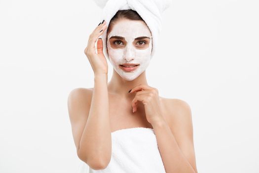 Beauty Skin Care Concept - Beautiful Caucasian Woman Face Portrait applying cream mask on her facial skin white background