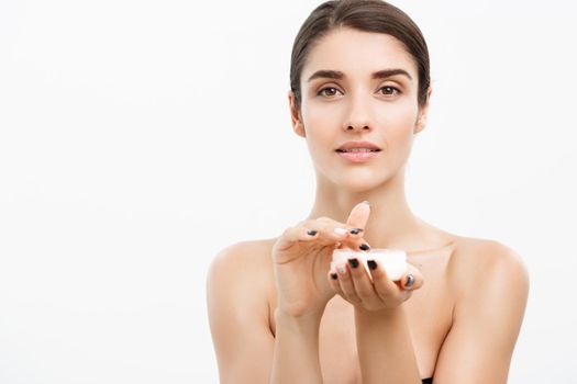 Beauty Youth Skin Care Concept - Beautiful Caucasian Woman Face Portrait smiling and holding cream jar for body and skin.Isolated over white background