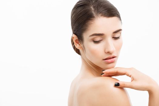 Beauty and Skin care concept - Close up Beautiful Young Woman touching her skin on white background