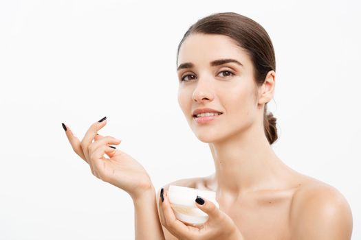 Beauty Youth Skin Care Concept - Beautiful Caucasian Woman Face Portrait smiling and holding cream jar for body and skin.Isolated over white background