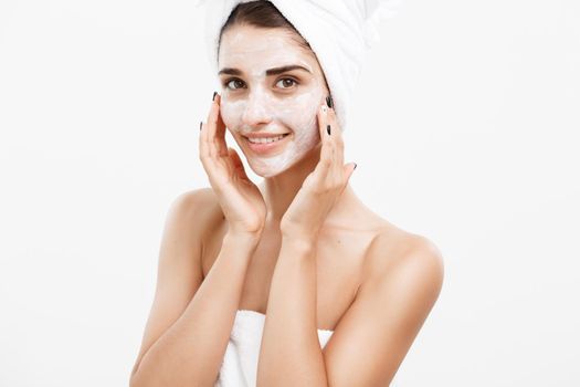 Beauty Skin Care Concept - Beautiful Caucasian Woman Face Portrait applying cream mask on her facial skin white background