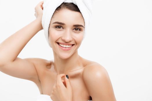 Beauty and Skin care concept - Beautiful caucasian Young Woman with bath towel on head covering her breasts, on white