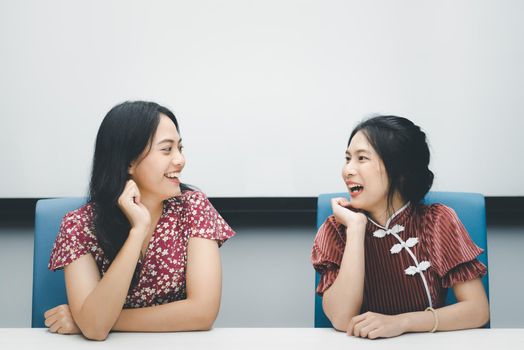 Asian pretty women in cheongsam chinese style great happy joyful and coworker discussion in meeting room in office with happy and smile in concept success, winner, successful or business