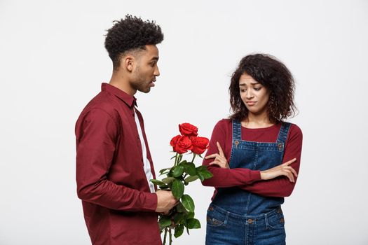 Valentine concept - young african american woman upset and ignore rose from her boyfriend