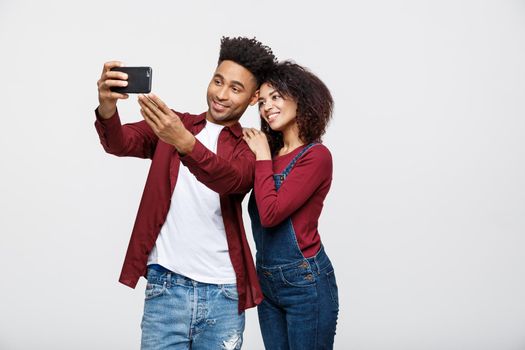 Young attractive African American Couple Pose For selfie pose with smart phone.