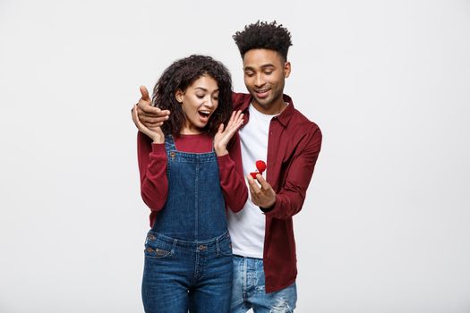 Young handsome african american man surprisingly ask her girlfriend for proposal.