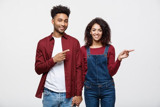 Young African American people in casual clothes looking away and point finger. isolated on white background.