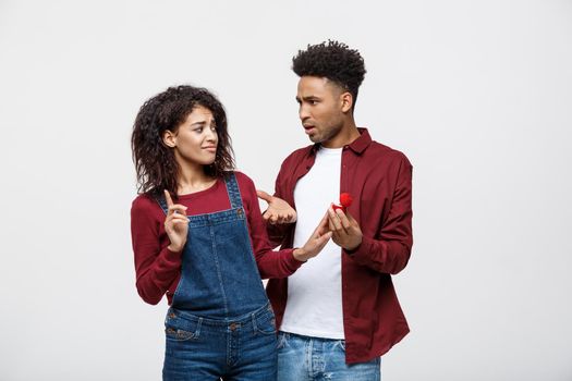 Young African American Scared girlfriend rejecting a marriage proposal. Humorous situation.