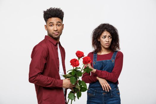 Valentine concept - young african american woman upset and ignore rose from her boyfriend