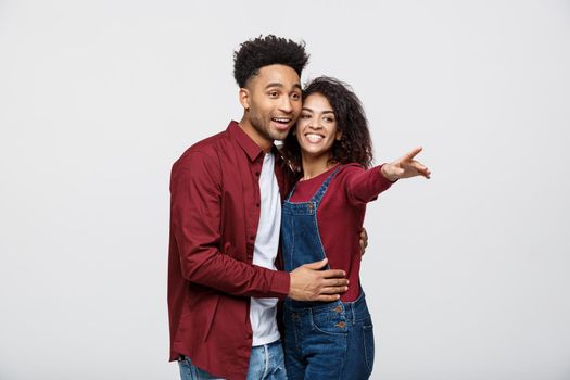 Young African American people in casual clothes looking away and point finger. isolated on white background.