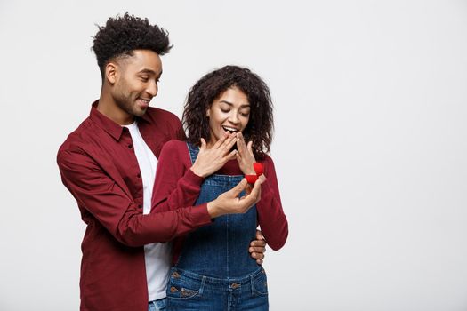 Young handsome african american man surprisingly ask her girlfriend for proposal.