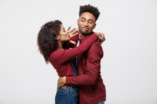 Close-up of African American young couple deny kissing over white background studio.