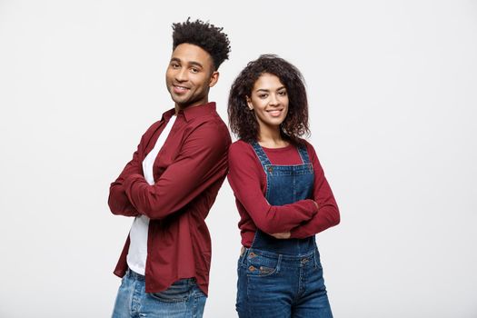 Cheerful hsppy man and woman with crossed hands standing back to back