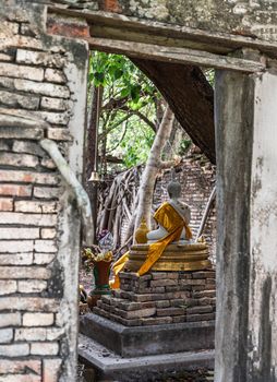 Nakhon Nayok, Thailand - Mar 21, 2020 : Many big tree roots covering The ancient church without roof inside there is a Buddha statue at The ancient of a 200 year old church. Wat Pah Krathum. Selective focus.
