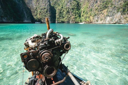 Old Machine of Fishing boat at the clear blue sea water in Thailand.