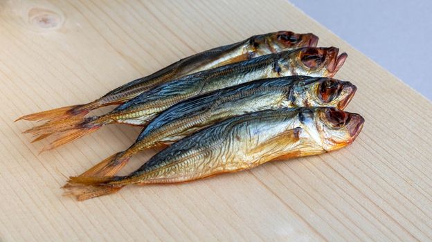Horse mackerel fish, cold smoked. Smoked fish close-up on a wooden background .Food industry.