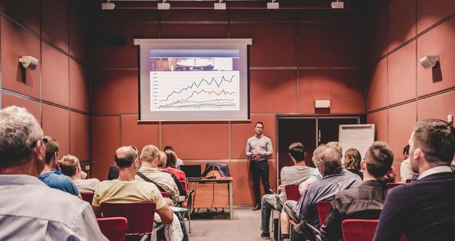 Speaker giving a talk in conference hall at business event. Unrecognizable people in audience at conference hall. Business and Entrepreneurship concept.