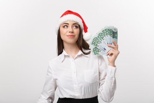Christmas and Financial concept - Young confident business woman showing money in front of her with happy face.