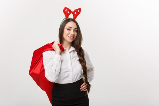 Christmas Concept - Young beautiful business woman in christmas theme holding santa red bag.