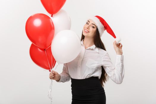 Business Concept - Beautiful young confident business woman with santa hat holding balloon celebrate for Christmas.