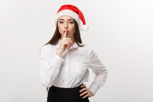 Business Concept - Modern caucasian business woman in the white studio background showing shh sign.