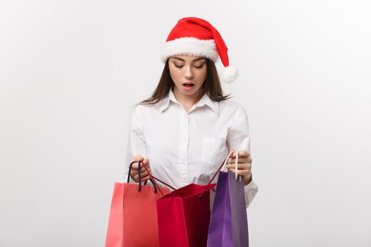 Christmas Concept - beautiful caucasian business woman shocking with gift inside shopping bag.