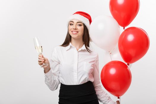 Christmas Celebration - Young beautiful business woman celebrating christmas with glass of champagne and balloon.
