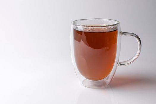 glass thermo mug with black tea on a white background. High quality photo