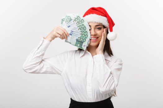 Christmas and finance concept - Young business woman showing money closing her face with surprise expression.