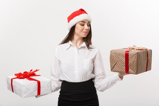 Christmas Concept - young happy caucasian business woman with santa hat choosing gift boxs with copy space on side.