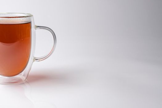 glass thermo mug with black tea on a white background. High quality photo