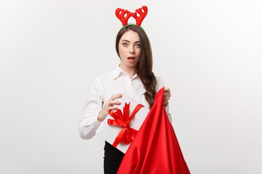 Christmas Concept - Young beautiful business woman surprise with present in santa bag.