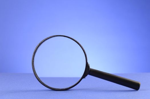 A magnify glass over a blue background for searching the details.