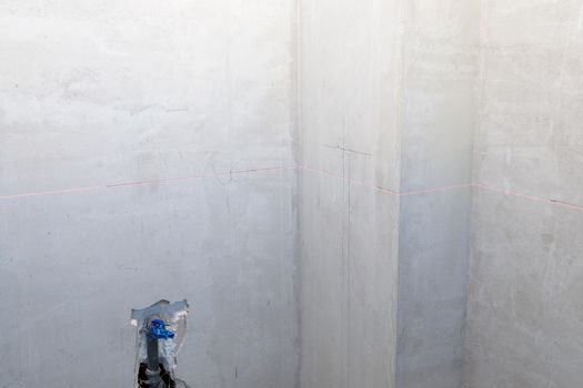 Laser marking of the level on the wall, construction, interior finishing works. Construction laser level for marking electrical outlets.
