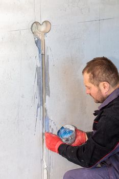 The electrician will prime the holes and channels for outlets and wires. Repair of apartments. Close-up